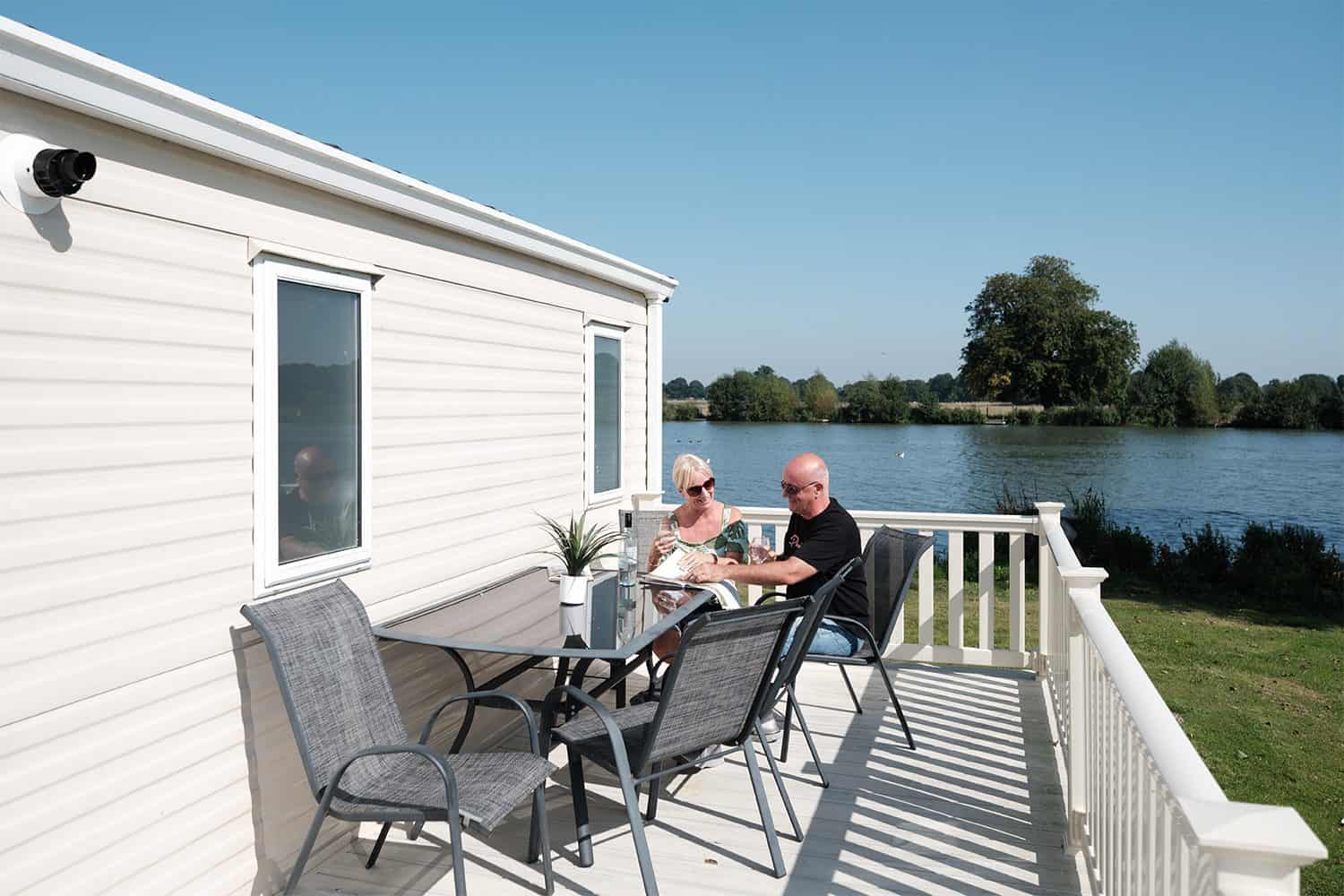 A couple sat on the decking outside their static caravan